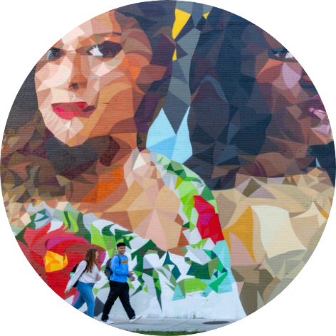 Students walking by a mural on campus